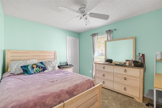 carpeted bedroom with ceiling fan and a textured ceiling