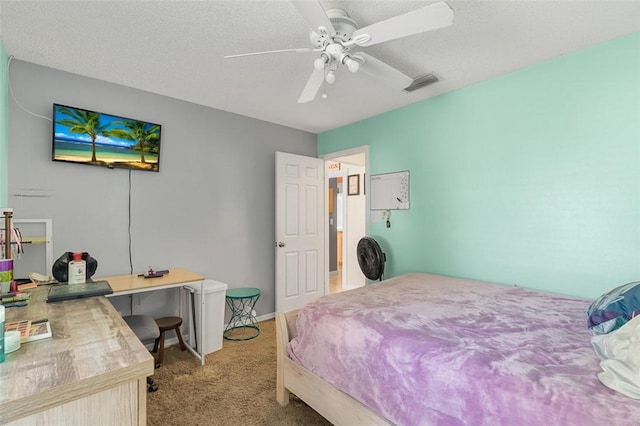 carpeted bedroom featuring ceiling fan and a textured ceiling