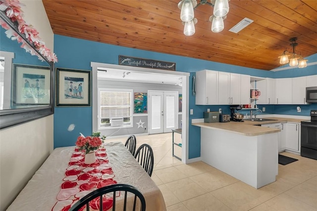 kitchen with white cabinetry, hanging light fixtures, black range with electric cooktop, and sink