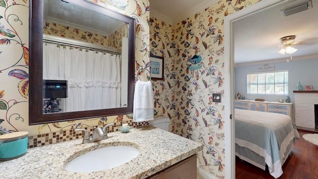 bathroom featuring hardwood / wood-style flooring, ceiling fan, vanity, and crown molding