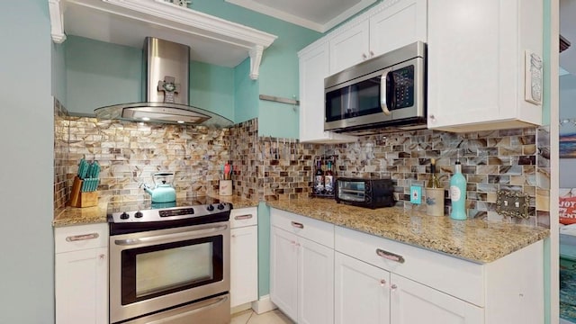 kitchen with white cabinetry, wall chimney exhaust hood, crown molding, and stainless steel appliances