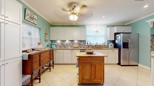 kitchen featuring crown molding, stainless steel refrigerator with ice dispenser, decorative backsplash, white cabinets, and ceiling fan with notable chandelier