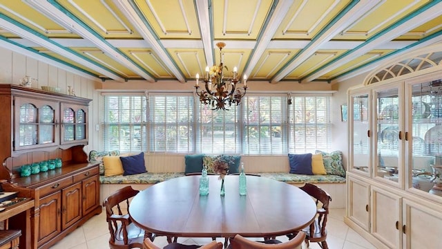 sunroom featuring beamed ceiling, coffered ceiling, a chandelier, and plenty of natural light