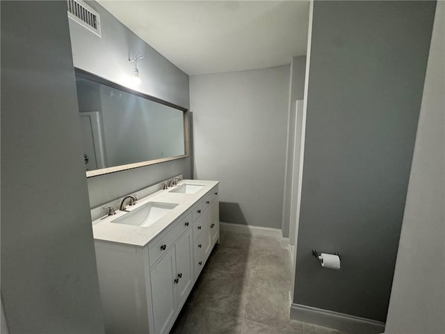 bathroom featuring a sink, visible vents, baseboards, and double vanity