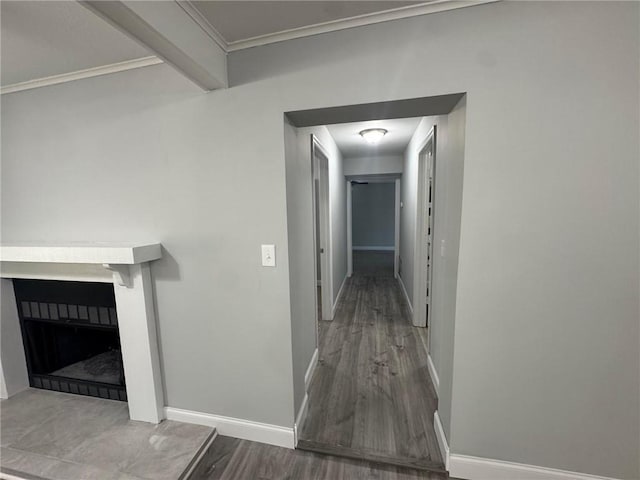 hall with beamed ceiling, baseboards, wood finished floors, and crown molding