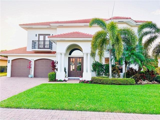 view of front of home with french doors, a balcony, and stucco siding