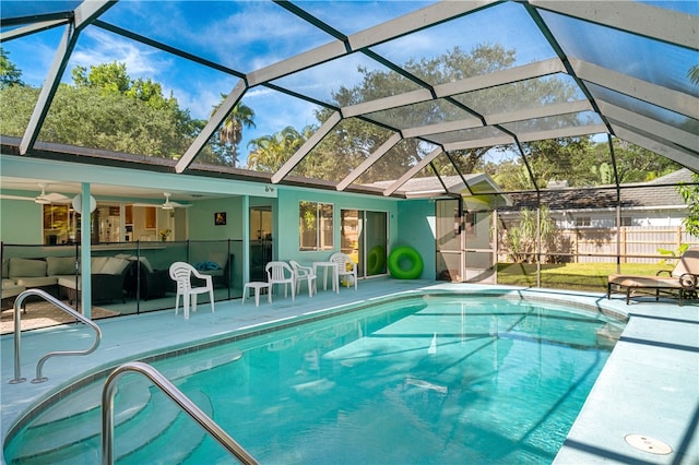 view of swimming pool with ceiling fan, a lanai, and a patio area