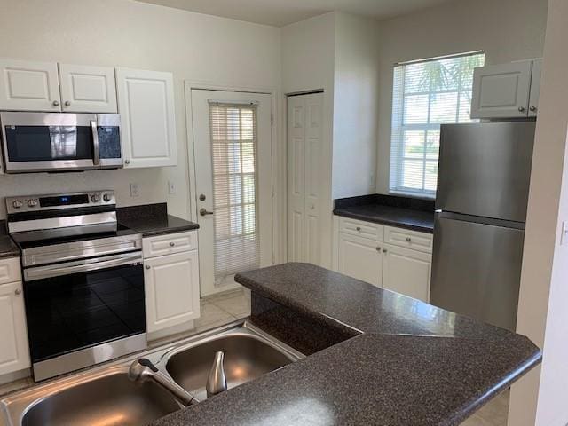 kitchen with white cabinetry, a wealth of natural light, and stainless steel appliances