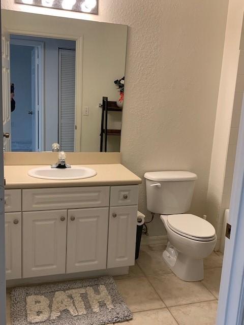 bathroom featuring vanity, tile patterned floors, and toilet