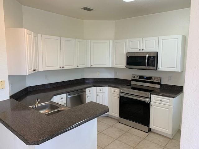 kitchen featuring white cabinetry, stainless steel appliances, and kitchen peninsula