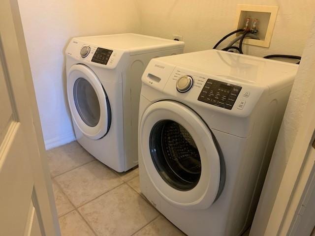 laundry area featuring light tile patterned flooring and washing machine and dryer