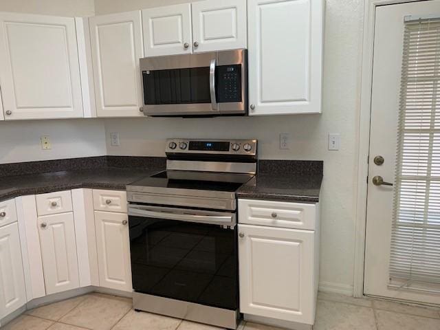 kitchen with white cabinetry, light tile patterned floors, and stainless steel appliances