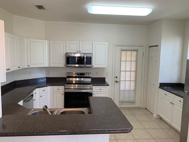 kitchen with white cabinetry, appliances with stainless steel finishes, sink, and light tile patterned floors