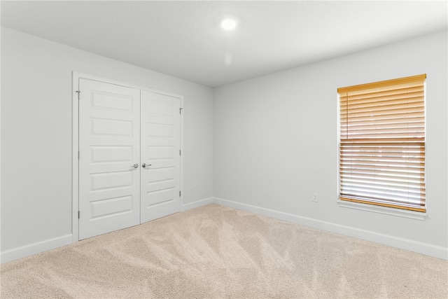 unfurnished bedroom featuring carpet floors and a closet