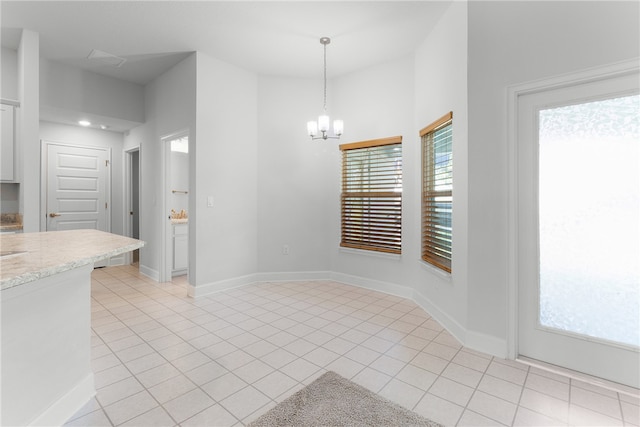 unfurnished dining area with a notable chandelier, a wealth of natural light, and light tile patterned floors