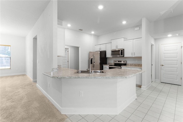 kitchen with sink, white cabinets, appliances with stainless steel finishes, and kitchen peninsula