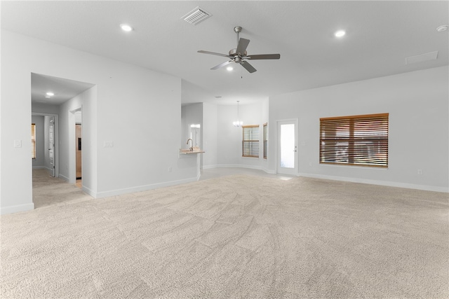 unfurnished living room featuring light carpet and ceiling fan