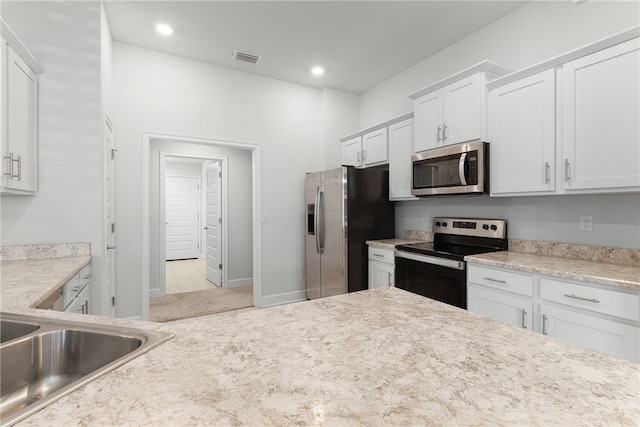 kitchen with sink, white cabinets, and stainless steel appliances