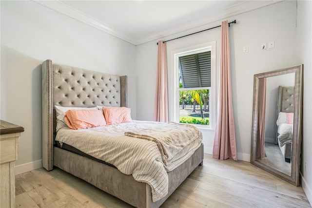 bedroom with ornamental molding and light hardwood / wood-style floors