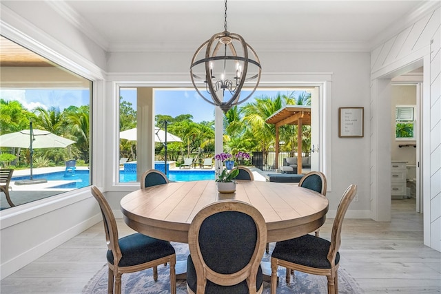 dining space featuring light hardwood / wood-style floors, a healthy amount of sunlight, and a notable chandelier