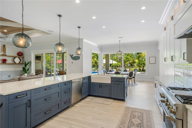 kitchen featuring white cabinets, hanging light fixtures, light hardwood / wood-style flooring, and appliances with stainless steel finishes