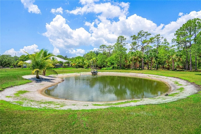 surrounding community with a water view and a lawn