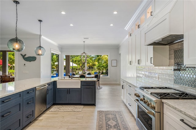 kitchen featuring pendant lighting, sink, white cabinetry, light wood-type flooring, and appliances with stainless steel finishes