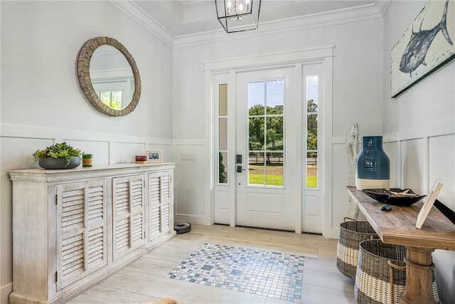 doorway featuring a wealth of natural light, crown molding, and light hardwood / wood-style flooring