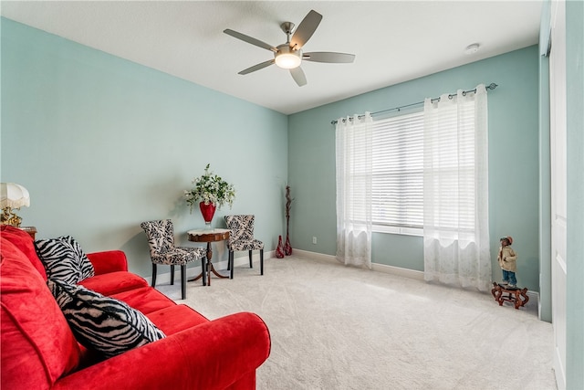 living area with light colored carpet and ceiling fan