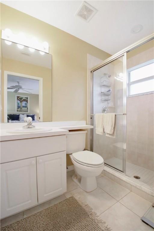 bathroom featuring tile patterned floors, vanity, toilet, and a shower with shower door