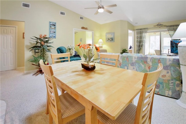 carpeted dining area with ceiling fan and lofted ceiling