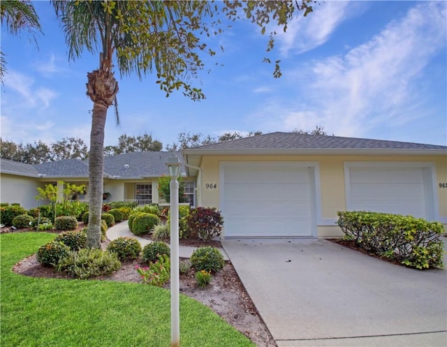 ranch-style home with a garage and a front lawn