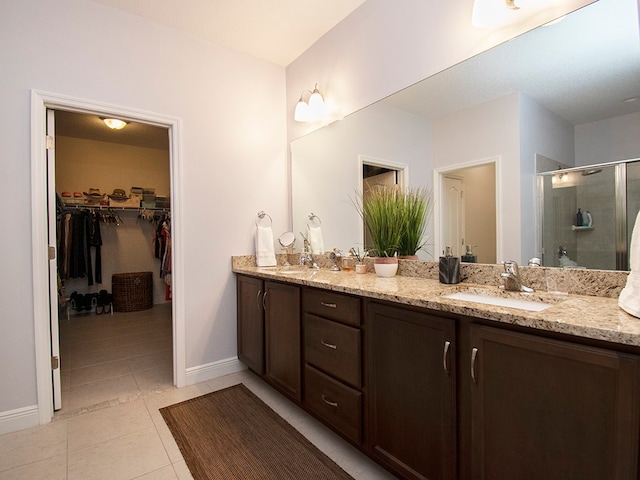 bathroom with walk in shower, vanity, and tile patterned floors