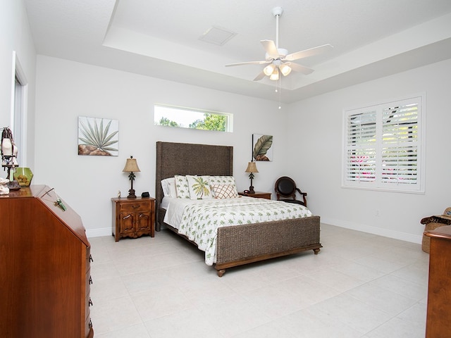 bedroom with ceiling fan and a raised ceiling