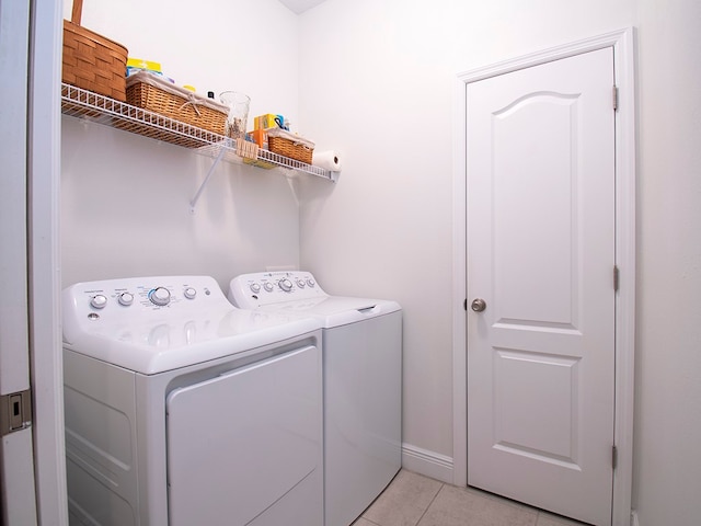 laundry area with washing machine and dryer and light tile patterned floors