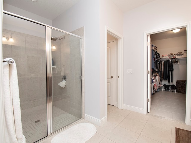 bathroom featuring a shower with shower door and tile patterned floors