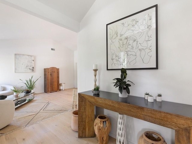 hallway featuring light hardwood / wood-style flooring and lofted ceiling