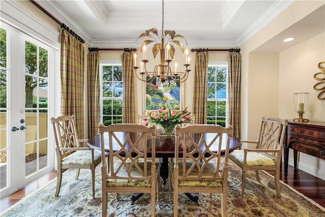 dining space featuring hardwood / wood-style floors, plenty of natural light, a notable chandelier, and a raised ceiling