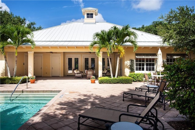 410 N Palm Island Cir, Vero Beach, FL 32963 - rear view of house featuring french doors, a patio area, a standing seam roof, an outdoor pool, and stucco siding
