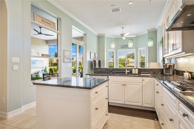 kitchen with dark stone countertops, extractor fan, and white cabinets