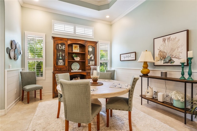 tiled dining room featuring ornamental molding, a towering ceiling, and plenty of natural light