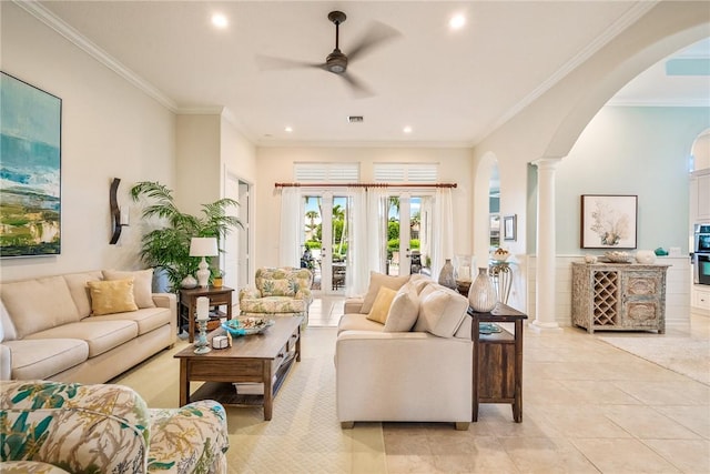 tiled living room featuring ceiling fan, ornamental molding, and ornate columns