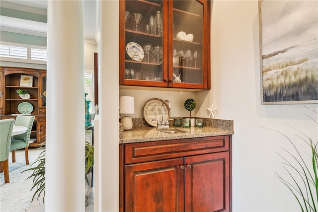 bar featuring carpet flooring, light stone counters, sink, and crown molding