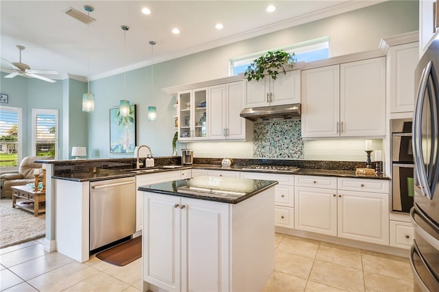 kitchen with sink, white cabinetry, decorative light fixtures, dark stone countertops, and appliances with stainless steel finishes