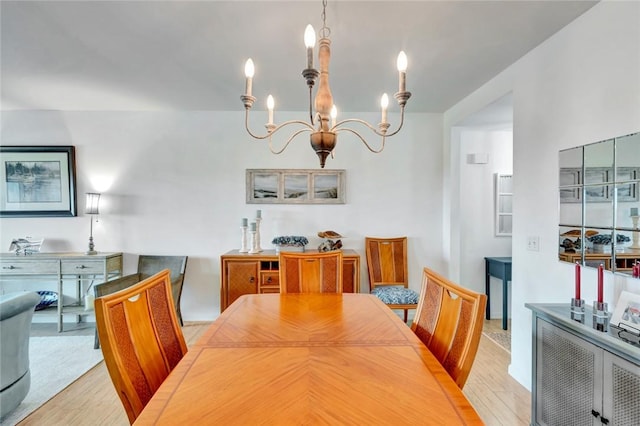 dining space with a chandelier and light wood-type flooring