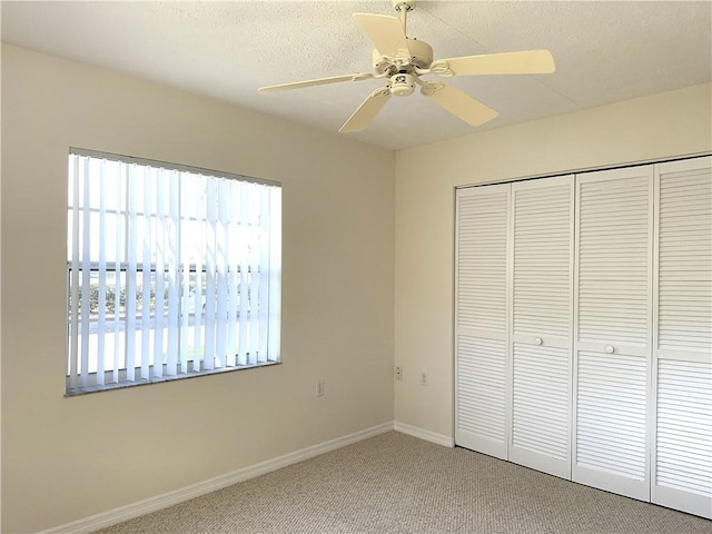 unfurnished bedroom with carpet flooring, ceiling fan, and a closet