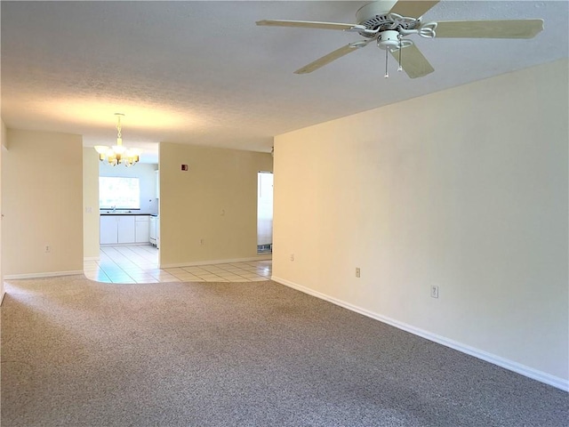 spare room with light carpet, ceiling fan with notable chandelier, and a textured ceiling