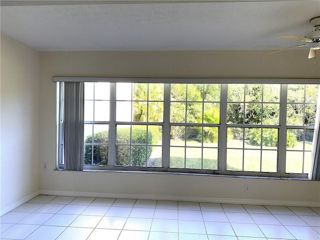 unfurnished room with light tile patterned floors and ceiling fan