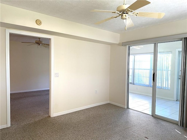 empty room featuring ceiling fan, a textured ceiling, and carpet flooring