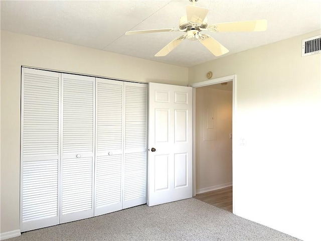 unfurnished bedroom featuring carpet flooring, ceiling fan, and a closet